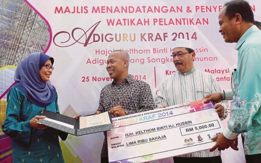 MOHD Kamil (dua dari kiri) menyerahkan watikah perlantikan Adiguru Kraf 2014 kepada Kelthom sambil diperhatikan Pengerusi Jawatankuasa Kebudayaan, Pelancongan dan Warisan Kelantan, Mejar (B) Md Anizam Ab Rahman (dua dari kanan), semalam. 