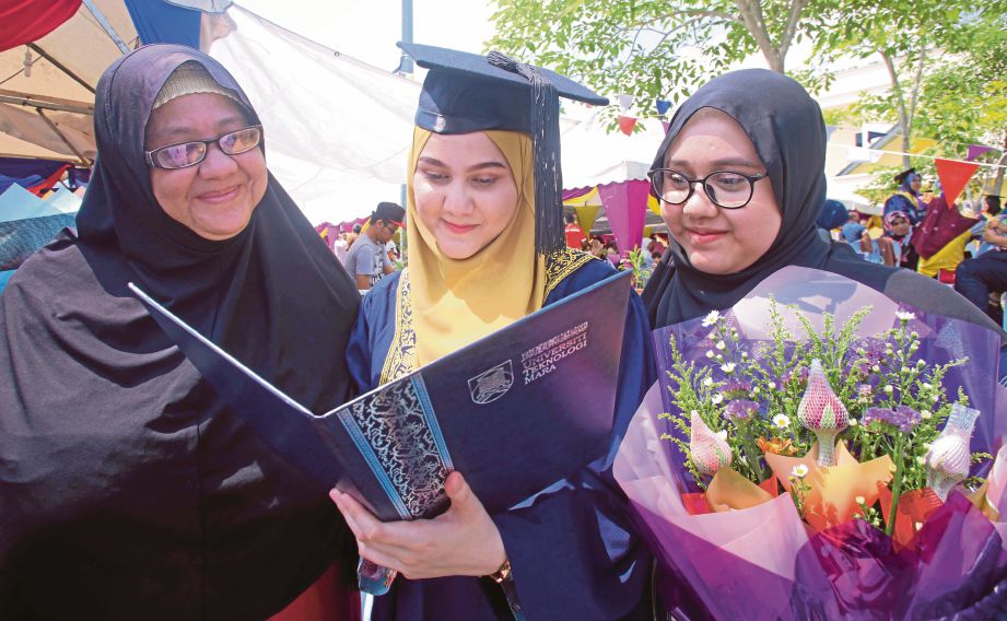 SITI Hajar (tengah) bersama ibunya, Nor’Azmah 55, (kiri) dan Siti Sarah Nadzari, melihat diploma yang diterima, semalam.