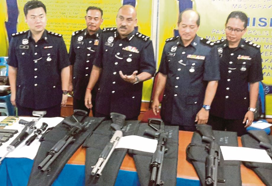  DEV (tiga dari kiri) menunjukkan senjata api yang dirampas di sebuah rumah di Tanjong Lobang, kelmarin.