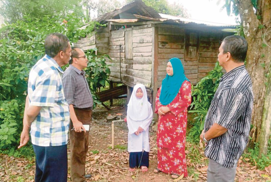 ZULFITRI (dua dari kiri) menziarahi Nor Aminah yang terpaksa tinggal di rumah uzur di Kampung Kubang Kayu, Changlun. 