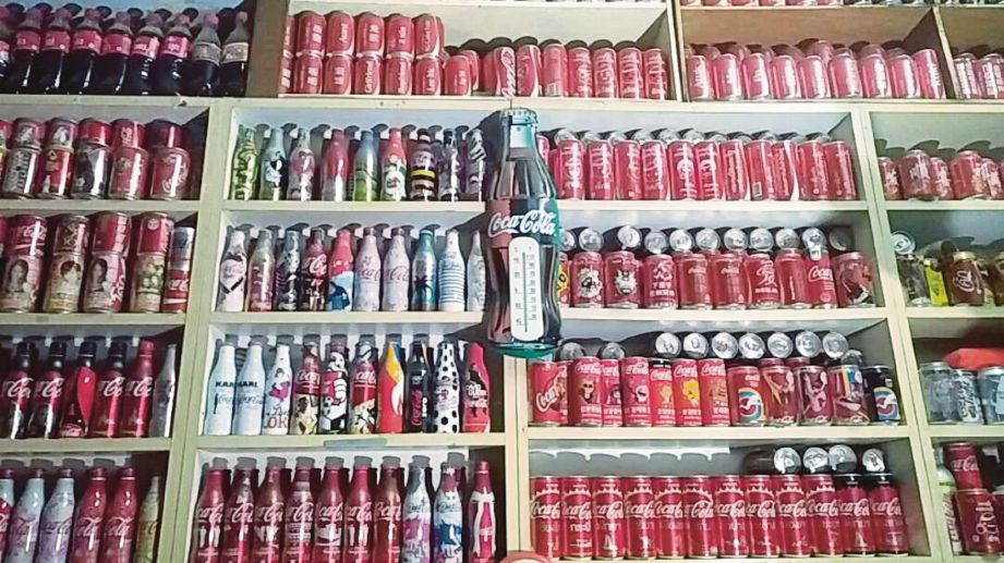ANTARA koleksi tin dan botol berjenama Coca-Cola yang disimpan di rak dalam bilik khas.