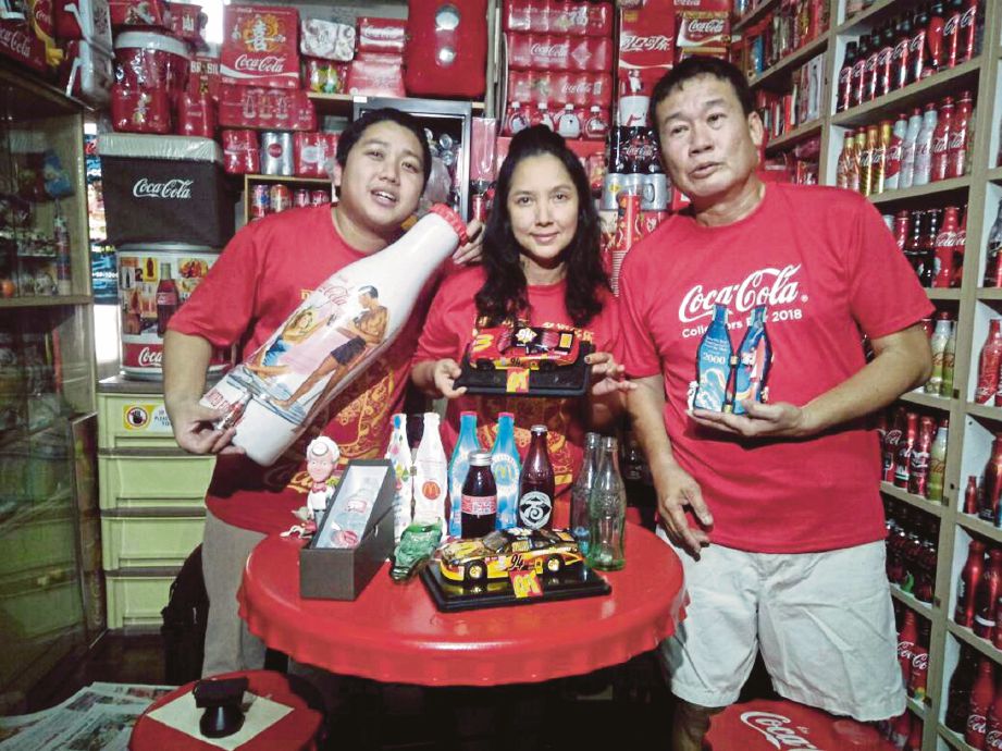 CHOON Chiek (kanan) bersama isteri dan anak tunggal mereka menunjukkan koleksi barangan Coca-Cola dan McDonald’s.
