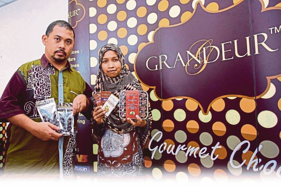 AIMILIA (kanan) dan Tengku Muazam menunjukkan coklat keluaran AOM Food. 