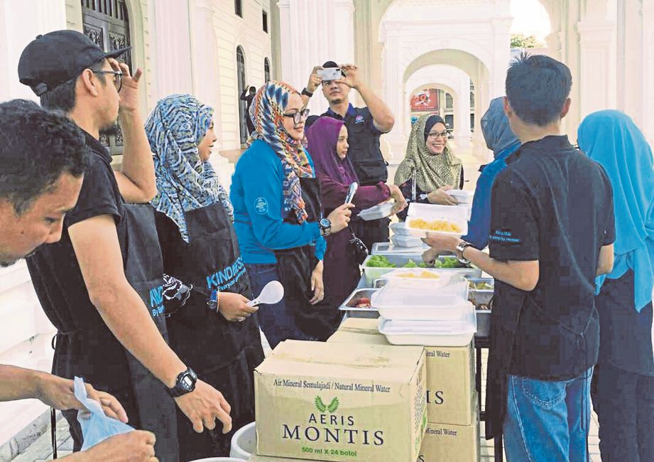 Sukarelawan Kindness Malaysia menyusun barangan ketika program di Masjid Zahir. 