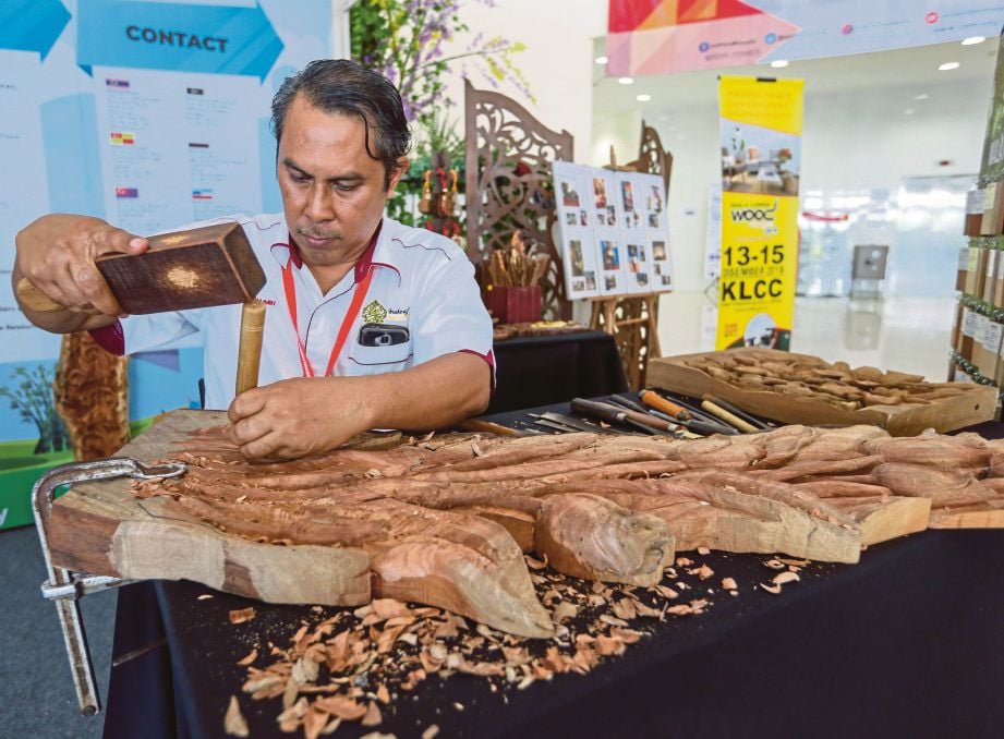 PENGUKIR  mengukir kayu untuk hiasan ruang tamu pada  Simposium Usahawan Perabot Bumiputera Kebangsaan 2019.