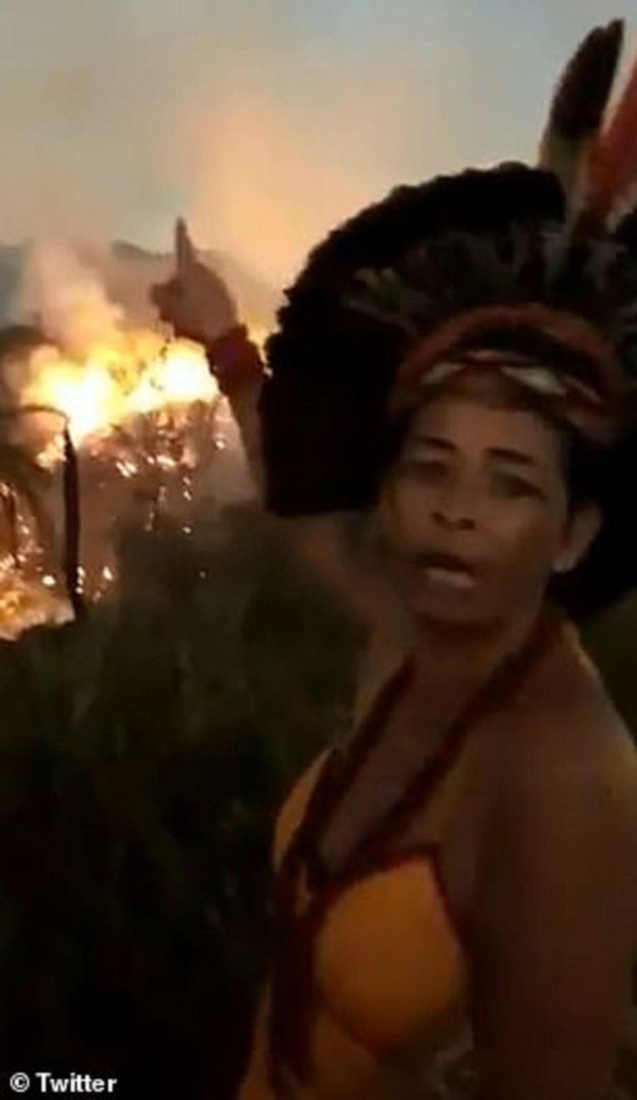 WANITA  berkenaan menangis menunjukkan kebakaran Amazon di belakangnya. FOTO Agensi 