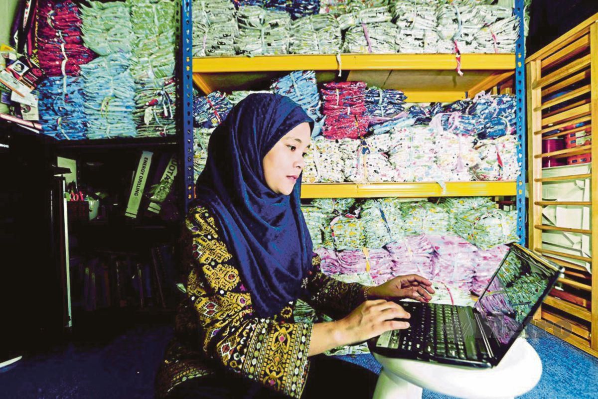 SEORANG usahawan,  Salhani Ibrahim menerima tempahan baju tidur kanak-kanak melalui platform e-dagang secara dalam talian di rumahnya.