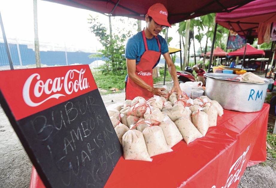 MUHAMMAD Thoriq menjual bubur lambuk warisan Kampung Baru di Bazar Ramadan Wangsa Melawati, Kuala Lumpur.