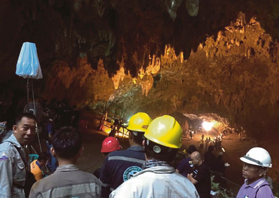 Anggota pasukan penyelamat berkumpul di depan gua. - Reuters