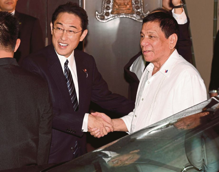 DUTERTE (kanan) disambut Menteri Luar Jepun, Fumio Kishida sebelum mesyuarat mereka di Tokyo, semalam. - AFP