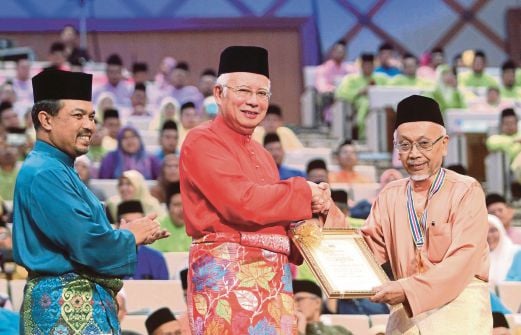 NAJIB menyampaikan sijil penghargaan kepada Penasihat Perundangan Syariah, Jabatan Peguam Negara, Tan Sri Sheikh Ghazali Abdul Rahman yang dipilih sebagai Tokoh Maal Hijrah 2014. 