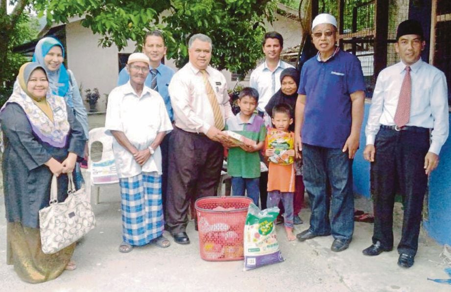 KAMANIZAM (lima dari kiri) menyampaikan sumbangan kepada keluarga Abdul Manap (tiga dari kiri).