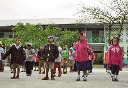 SEKUMPULAN murid di sebuah sekolah rendah di Korat yang memakai baju sejuk memanaskan badan sebelum masuk ke kelas, kelmarin.