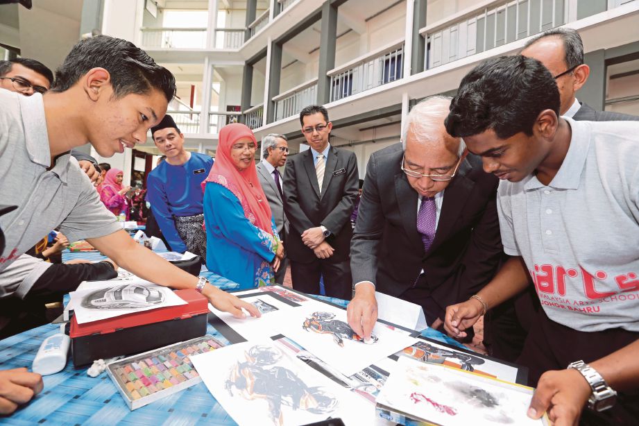 MAHDZIR (dua dari kanan) mewarnakan lukisan selepas merasmikan Sekolah Seni Malaysia Johor, semalam.