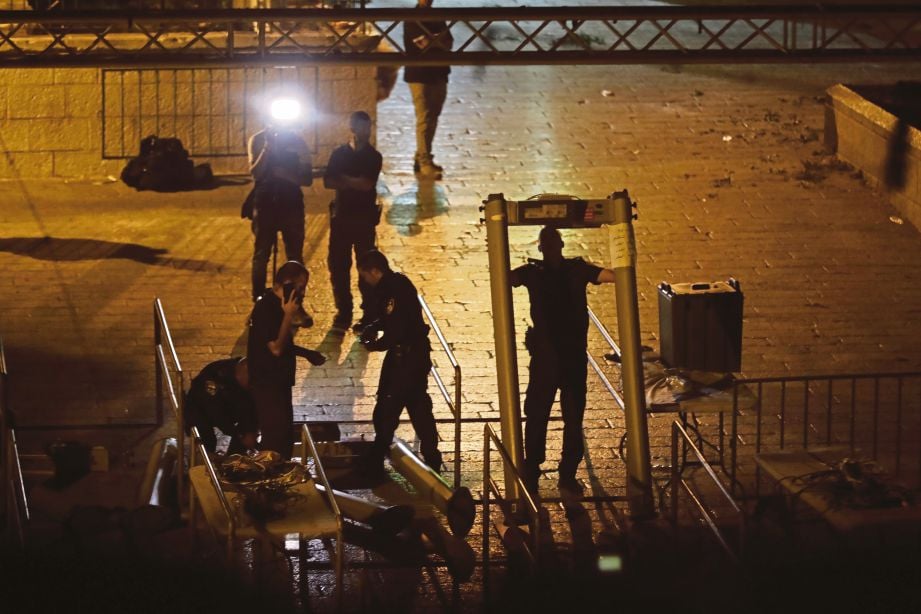 ANGGOTA keselamatan Israel menurunkan penghadang keselamatan di Pintu Singa, laluan utama ke pekarangan Masjid Al-Aqsa. - AFP 