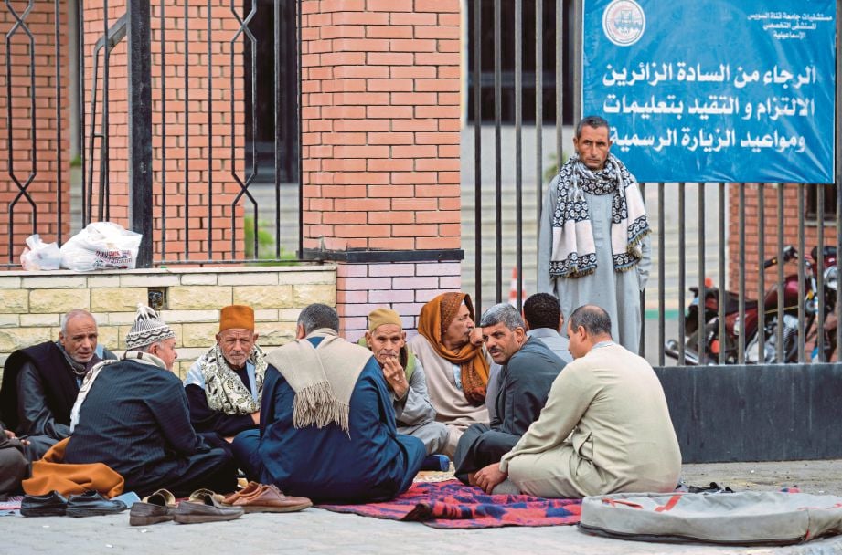 AHLI keluarga mangsa yang cedera berkumpul di luar sebuah hospital di bandar Ismailia semalam. - AFP