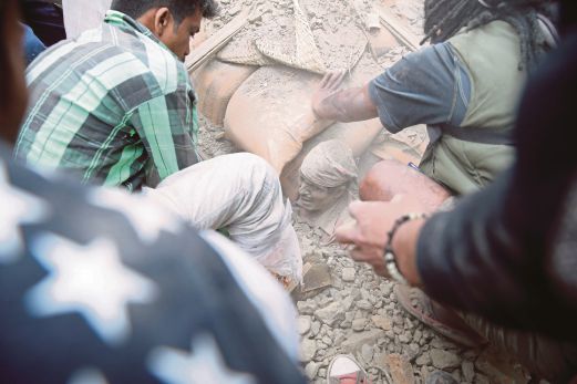 ORANG ramai cuba mengeluarkan seorang lelaki yang terperangkap dalam runtuhan bangunan di Kathmandu.