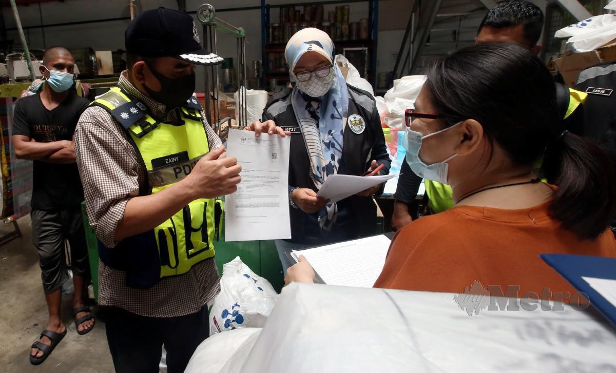 NOORZAINY (dua dari kiri) memeriksa surat kebenaran beroperasi MITI ketika melakukan pemeriksaan di sebuah kilang plastik di Mak Mandin, hari ini. FOTO Danial Saad.