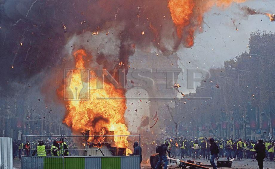 PERUSUH jaket kuning membakar timbunan kayu dekat dataran Champs Elysee. - Agensi 