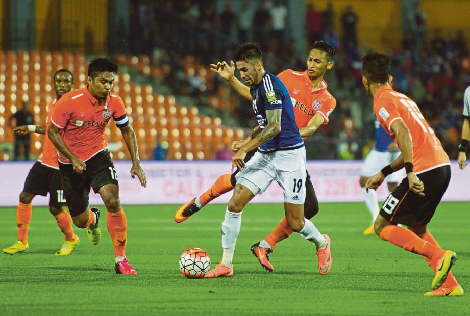 TIGA pemain FELDA United mengekang pergerakan penyerang Johor DT.