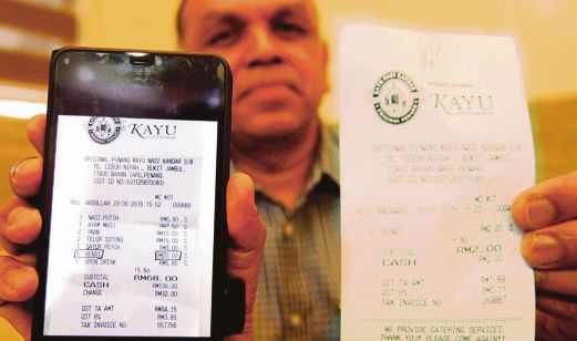 Burhan menunjukkan dua resit berbeza (kiri) yang dikatakan tersilap tekan oleh pekerjanya dan yang (kanan) harga sebenar bendi ketika KPDNKK membuat pemeriksaan di restoran itu di Bukit Jambul, semalam.
