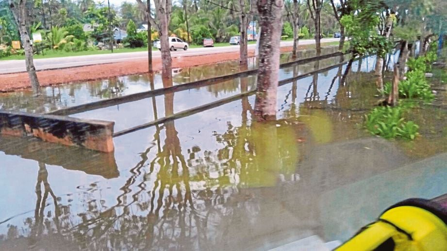 Parit di hadapan rumah penduduk  dipenuhi air banjir di Parit Baru. 