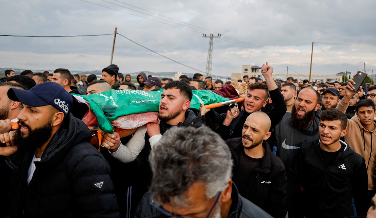 PENDUDUK Palestin mengangkat jenazah Wissam Khashan yang terkorban dalam serbuan Israel di Tebing Barat. FOTO Reuters.