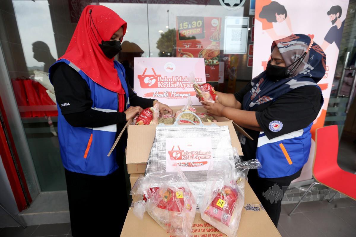 WAKIL Persatuan Kebajikan Usiamas Malaysia cawangan Selangor membantu mengagihkan ayam mentah sempena Program Titipan Kasih Harian Metro Bersama Kedai Ayamas - Bakul Makanan Kedai Ayamas di Bandar Puchong Utama. 