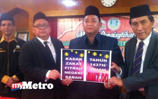 MOHD Suhaili (dua kanan) menunjukkan jumlah kadar zakat fitrah yang diumumkan tahun ini. FOTO Mohd Adam Arinin