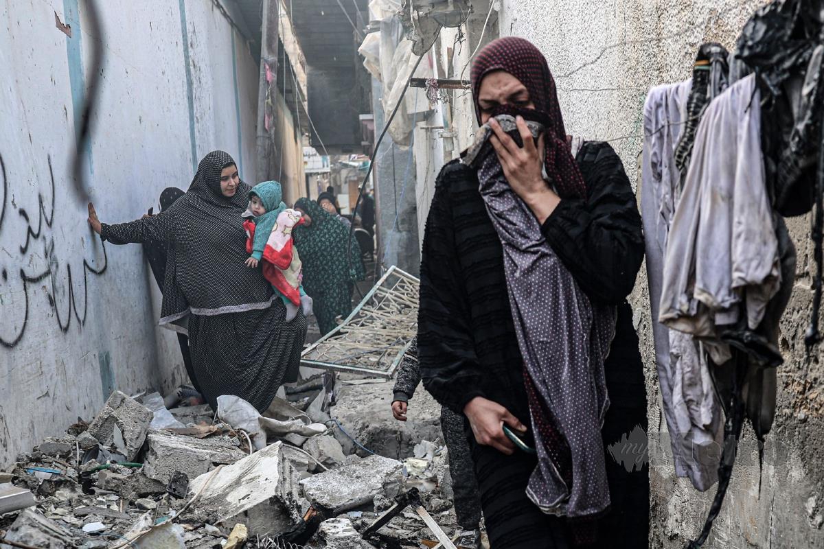 PENDUDUK Palestin menyelamatkan diri di kawasan runtuhan susulan serangan Israel di Rafah. FOTO AFP