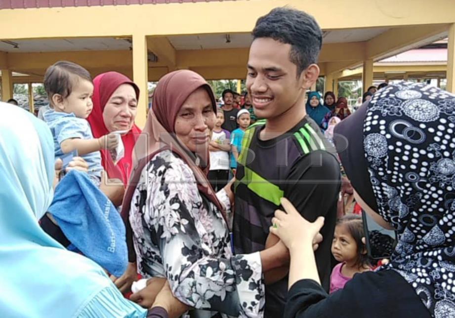 AMIRUL dipeluk neneknya, Rokiah Kadir, 57, sebaik tiba dengan selamat di Jeti LKIM Kuala Sala. FOTO Zuliaty Zulkiffli