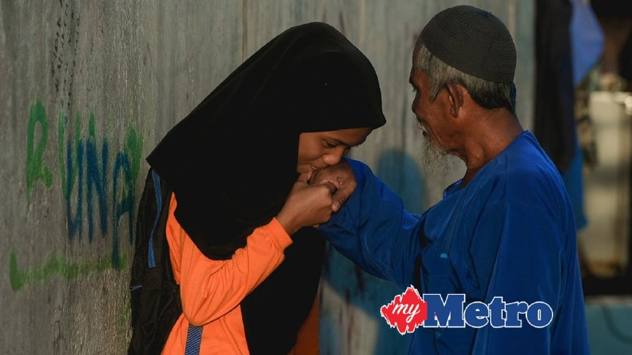 ERMIDA bersalaman bersama bapanya, Eduar sebelum pergi ke sekolah. FOTO Muhammad Sulaiman