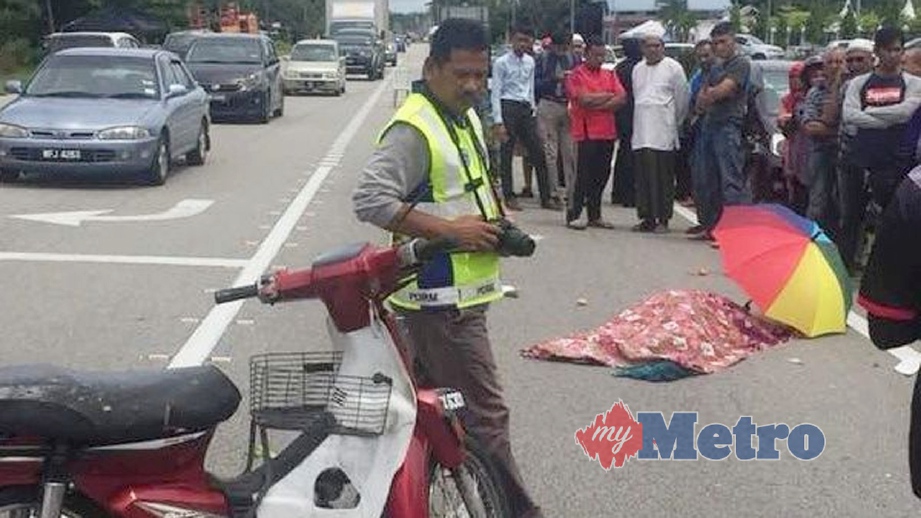 ANGGOTA polis memeriksa motosikal yang terbabit dalam kemalangan yang mengorbankan seorang ibu. FOTO Rosli Ilham
