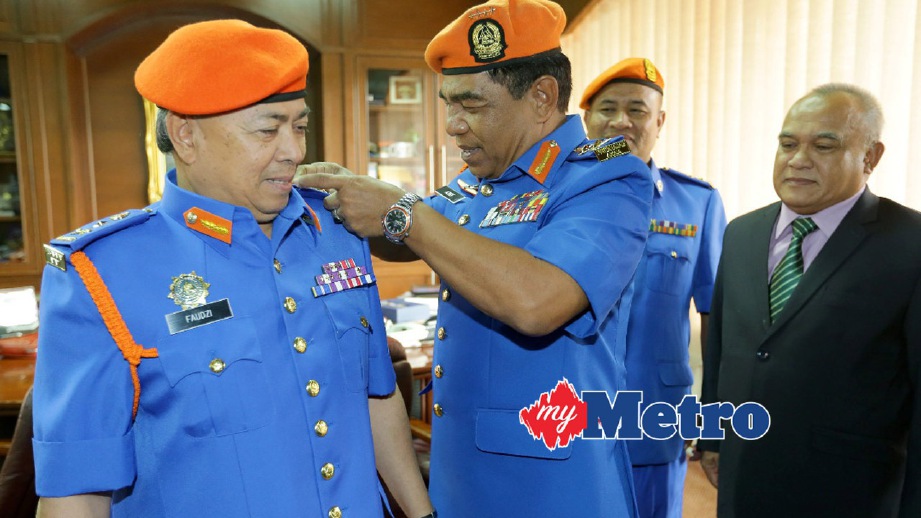AZMY memakaikan pangkat Penolong Pesuruhjaya Kehormat (Pertahanan Awam) kepada Mohd Faudzi. FOTO Fathil Asri