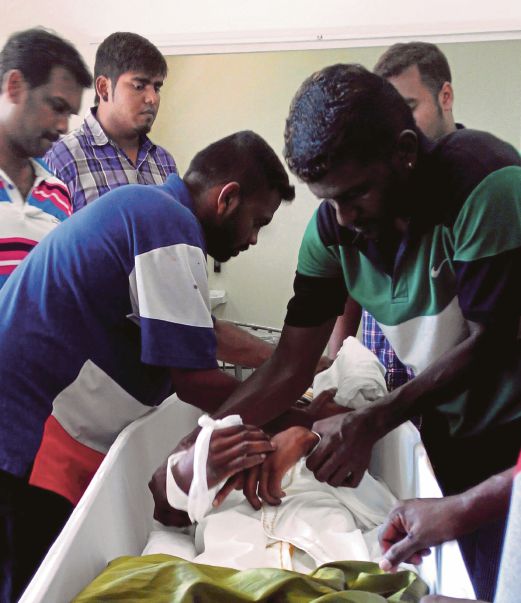 KELUARGA dan rakan mangsa menguruskan mayat mangsa selepas selesai dibedah siasat di Hospital Port Dickson untuk upacara pengebumian.