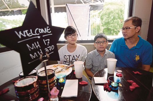 SUAMI kepada Ketua Pramugari MH17 (Lee Hui Pin), Wong Kin Wah (kanan) 43, bersama anaknya, Wong Hon Kai (tengah) 11, dan Wong Ruiqi (kiri) 14, hadir ke majlis rumah terbuka.
