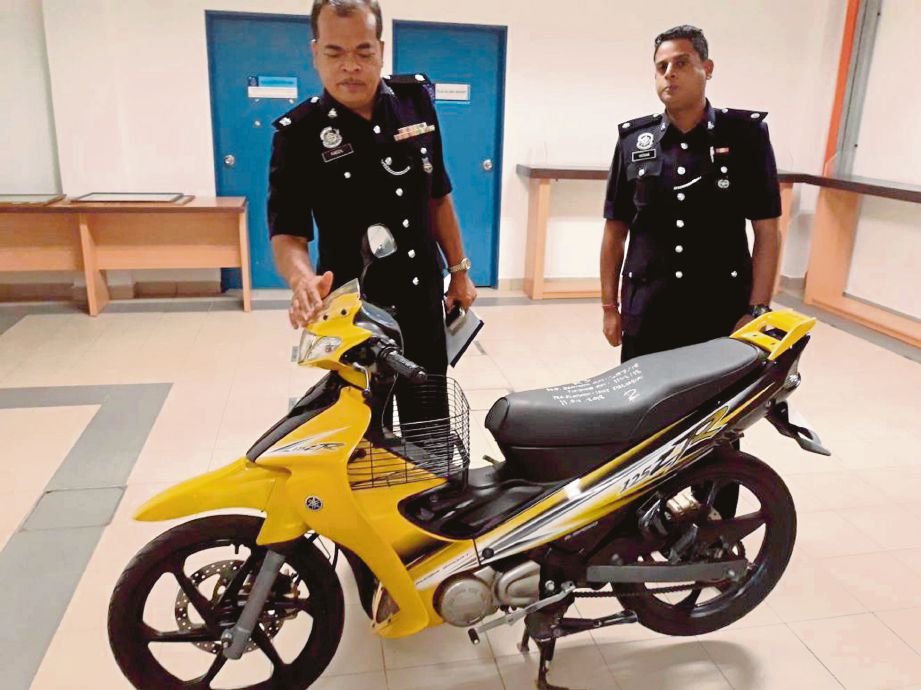  FADZIL  (kiri)  memeriksa motosikal yang digunakan suspek.