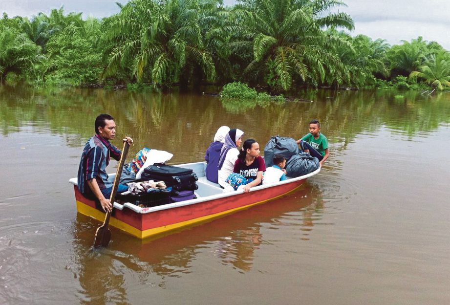 MANGSA banjir dari Kampung Padang Kemunting menaiki perahu untuk berpindah ke pusat pemindahan banjir.