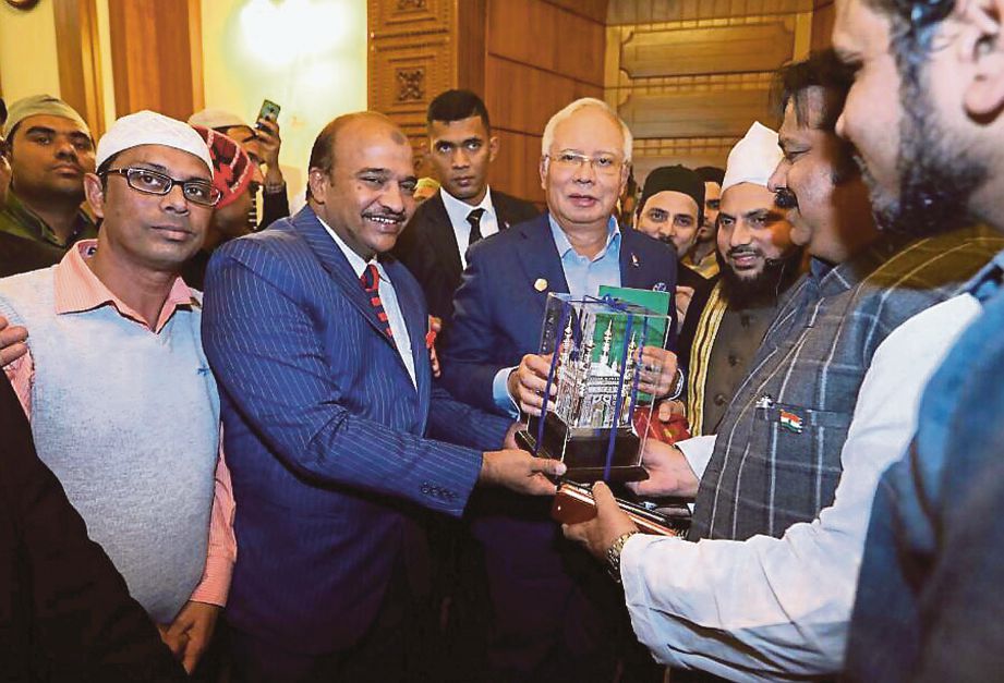 NAJIB menerima cenderahati daripada Imam Masjid Parlimen India Imam Mohibullah Nadvi (tiga dari kanan) selepas menunaikan solat Jumaat, semalam.