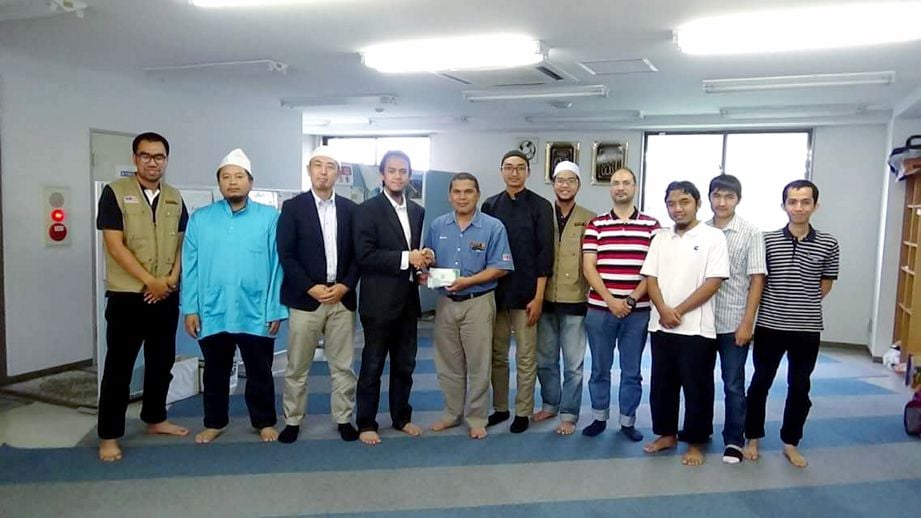 AZIZAN (empat dari kiri) menerima cek sumbangan Muslim Care Malaysia Society yang diserahkan oleh Zulkifli di Masjid Nishi-Chiba, Jepun.