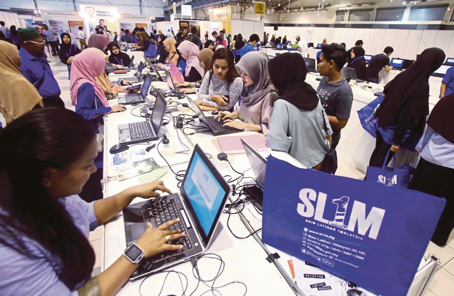  PENGUNJUNG mengisi borang pendaftaran pencari kerja pada Program Temuduga Terbuka yang dianjurkan SL1M di MITC, Ayer Keroh, semalam. 