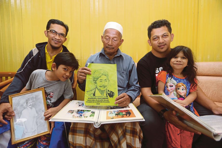 WAN Abd Ghani (tengah) bersama dua anak dan dua cucunya melihat buku yang mengandungi sejarah Wan Embong.