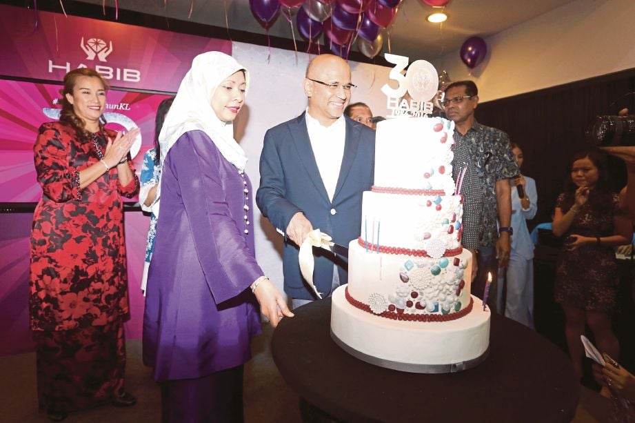  Meer  (tengah) bersama isteri,  Zarida (dua dari kiri) memotong kek sempena sambutan 30 tahun Habib di bilik pameran  Semua House, Kuala Lumpur, semalam. 