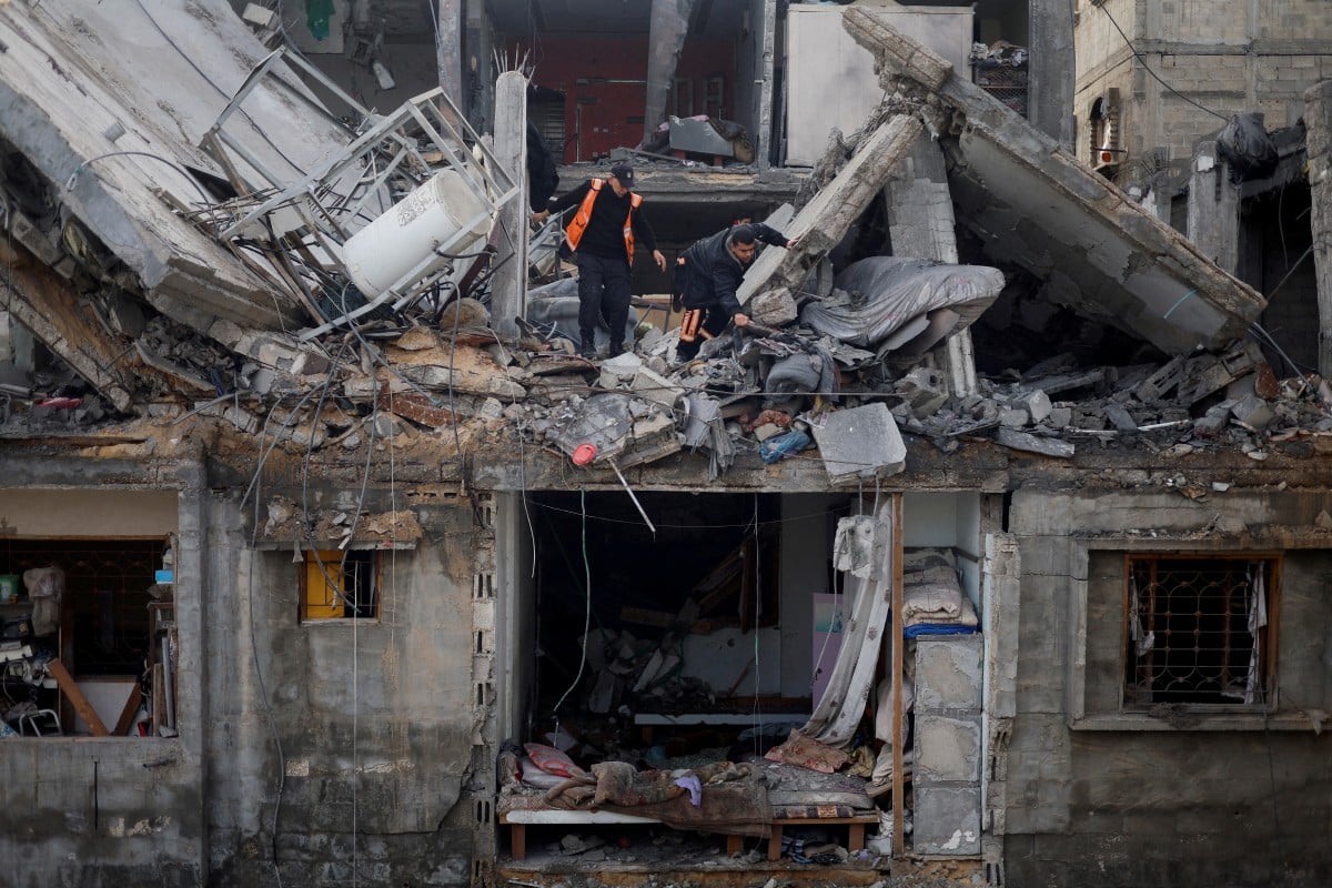 PENDUDUK Palestin memeriksa bangunan yang musnah akibat serangan Israel di Rafah. FOTO Reuters.