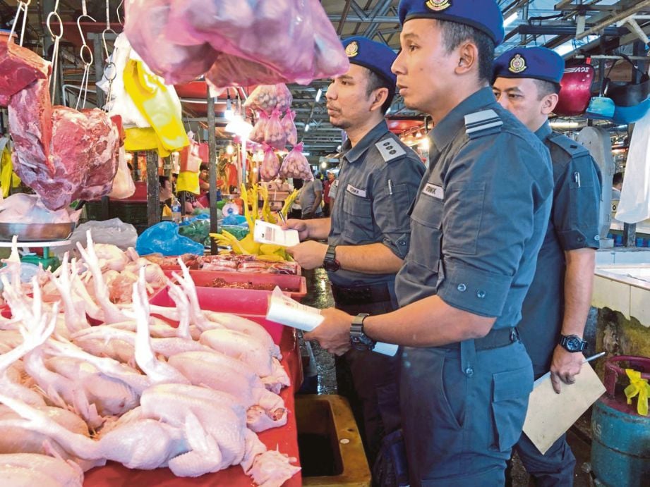 ANGGOTA  penguat kuasa KPDNKK memeriksa harga ayam di Pasar Jalan Raja Alang. 
