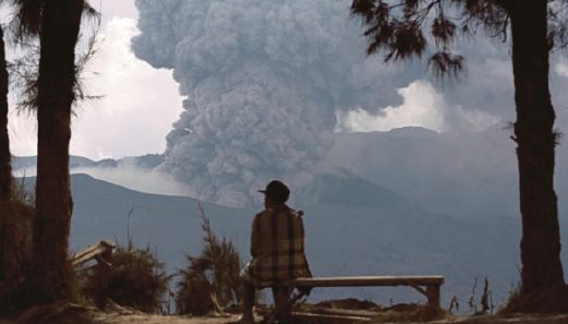SEORANG penduduk berehat dengan latar belakang gunung Bromo yang meletus di Ngadisari, Probolinggo di Jawa Timur.