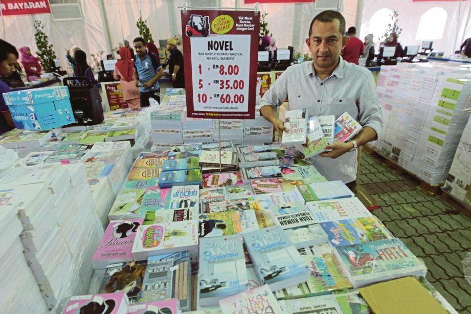 AHMAD Azim menunjukkan sebahagian  novel yang akan dijual sempena Pesta Buku Kelantan 2018.