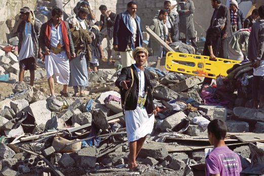 MILITAN Huthi dan penduduk tempatan berkumpul di runtuhan rumah yang musnah  dibedil pesawat pejuang Arab Saudi di Sanaa, Yaman semalam. 