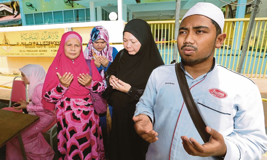  Pengunjung, Mohd Zakwan Abd Samad (kanan) membaca doa sambil diaminkan pengunjung lain  ketika melawat   Pusat Tahfiz Darul Quran Ittifaqiyah, semalam.