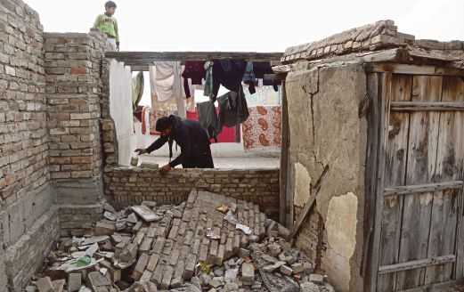 SEORANG penduduk di Peshawar, Pakistan memeriksa dinding rumahnya yang runtuh akibat gempa bumi kelmarin.